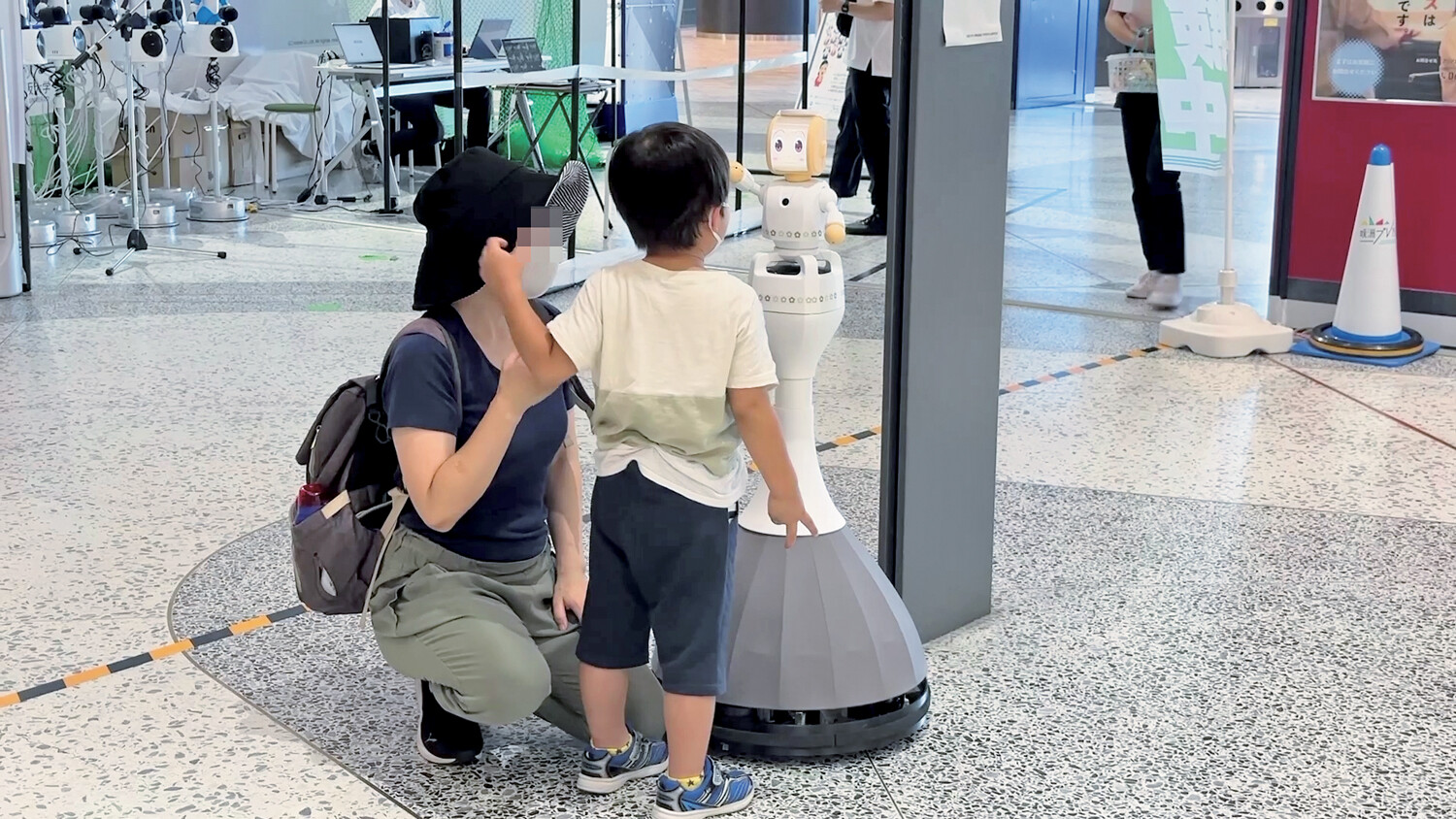 遠くにいる人がアバター（分身ロボット）を使って親子と会話している様子©ATR